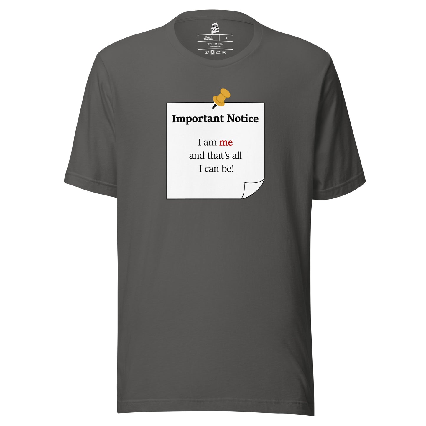 A unisex classic cotton asphalt grey t-shirt featuring a printed black-outlined square note with a white background and a yellow pushpin at the top centre. The note displays the slogan: "Important notice: I am me that's all I can be" in black, with the word me highlighted in bold red for emphasis.