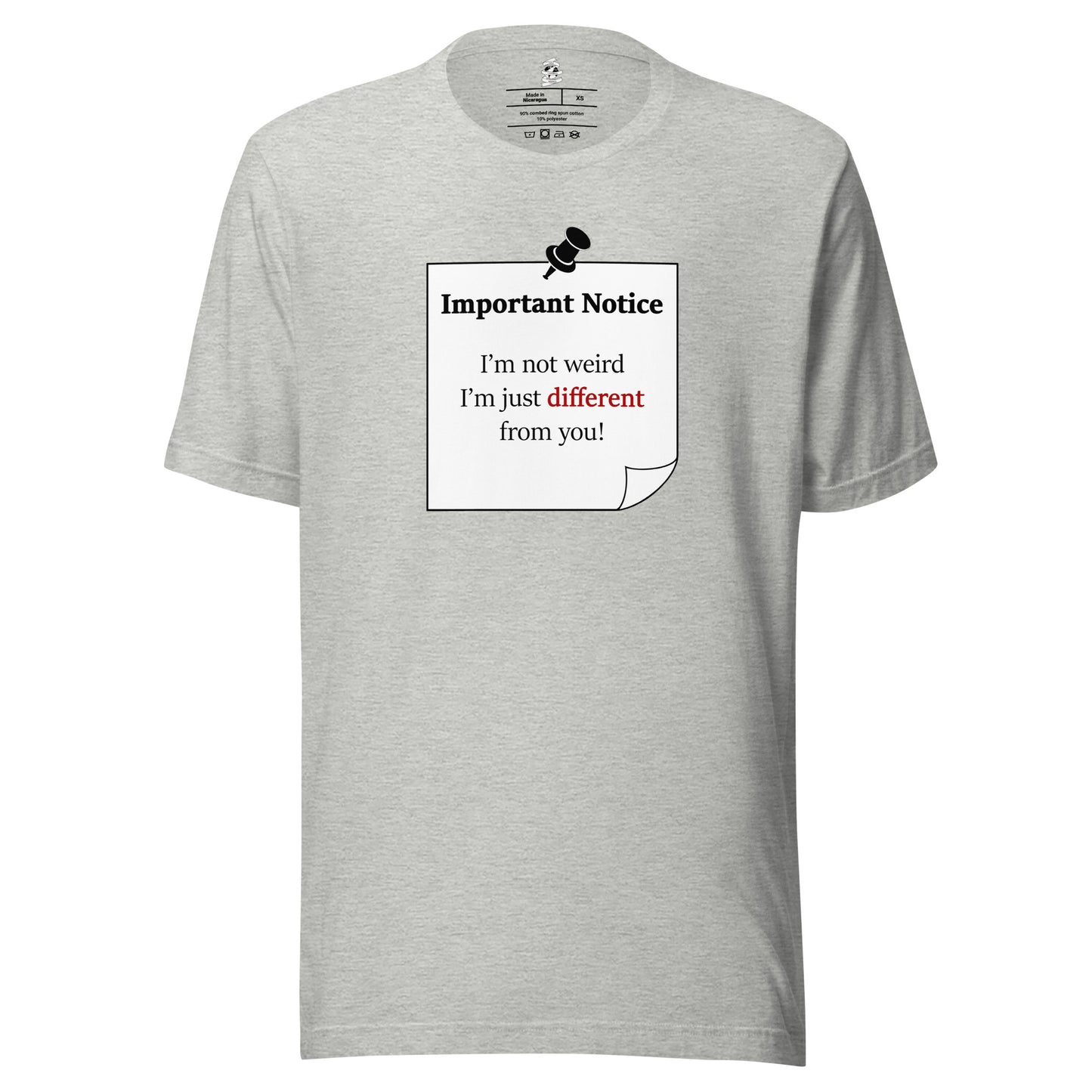 A unisex athletic-heather grey classic cotton t-shirt, featuring a printed black-outlined square note with a white background and a black pushpin at the top centre. The note displays the slogan: "Important notice: I’m not weird, i'm just different from you! with the word different highlighted in bold red for emphasis.