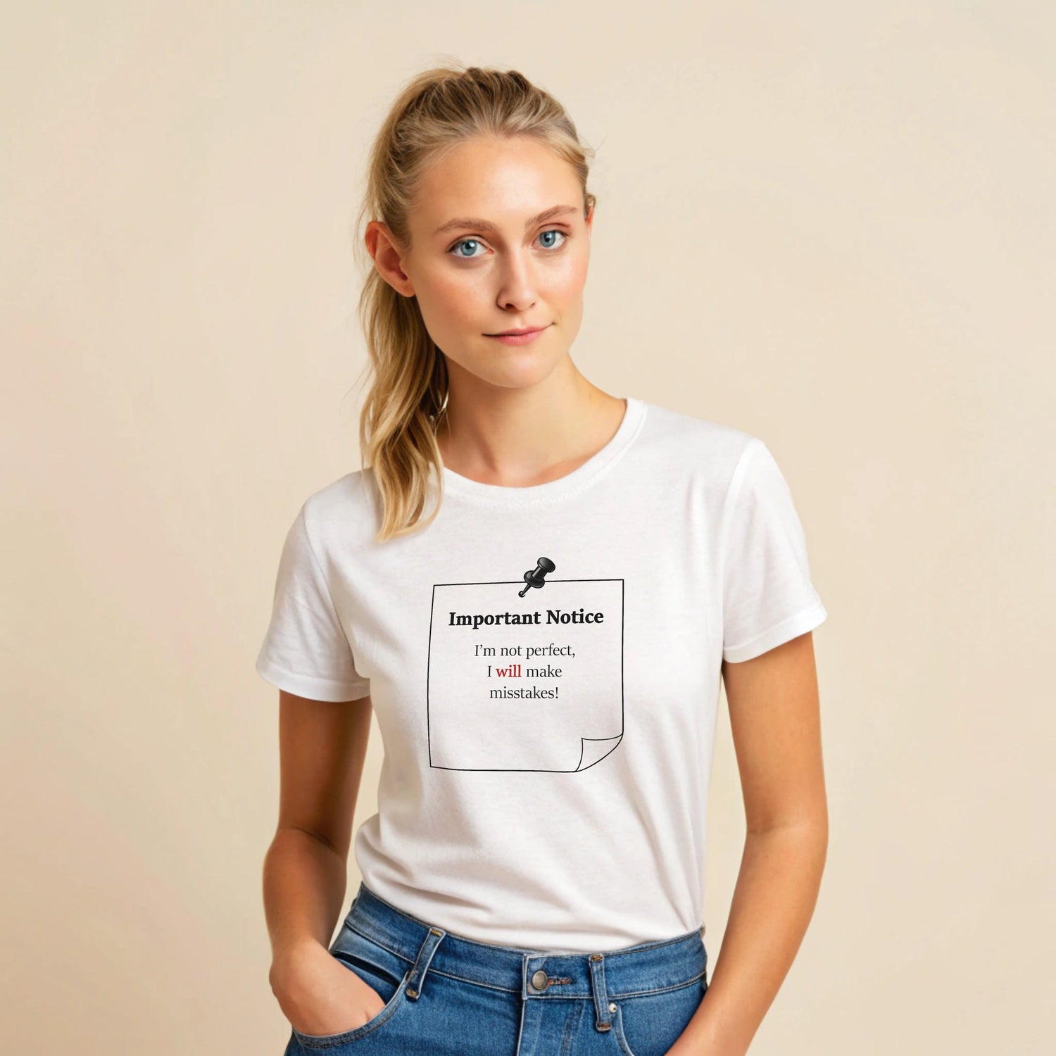 A woman in blue jeans wearing a white classic cotton t-shirt featuring a black-outlined square note with a black push pin. The note displays the slogan: 'Important Notice: I’m not perfect, I will make mistakes,' with 'will' in bold red for emphasis.
