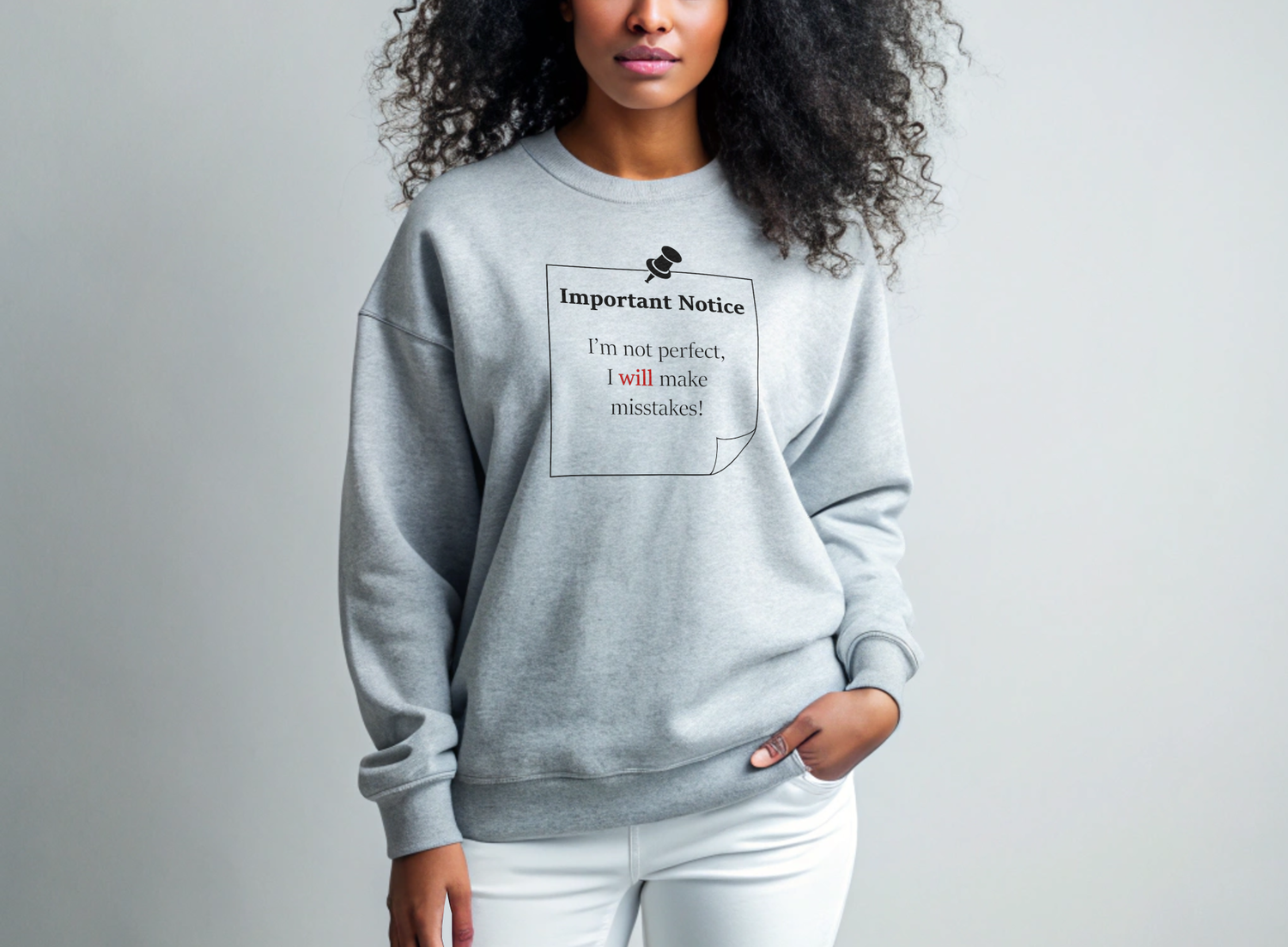 A woman in white leggings wearing a sporty grey jumper featuring a black-outlined square note with a black push pin. The note displays the slogan: 'Important Notice: I’m not perfect, I will make mistakes,' with 'will' in bold red for emphasis.