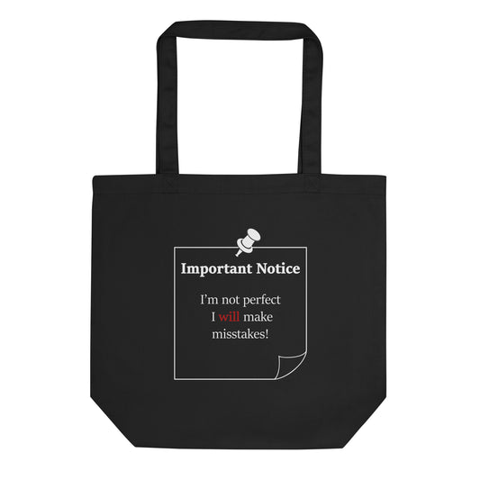 A small organic cotton twill black tote featuring a printed white-outlined square note and a white pushpin at the top centre. The note displays the slogan: "Important notice: I’m not perfect, I will make mistakes" in black, with the word will highlighted in bold red for emphasis.