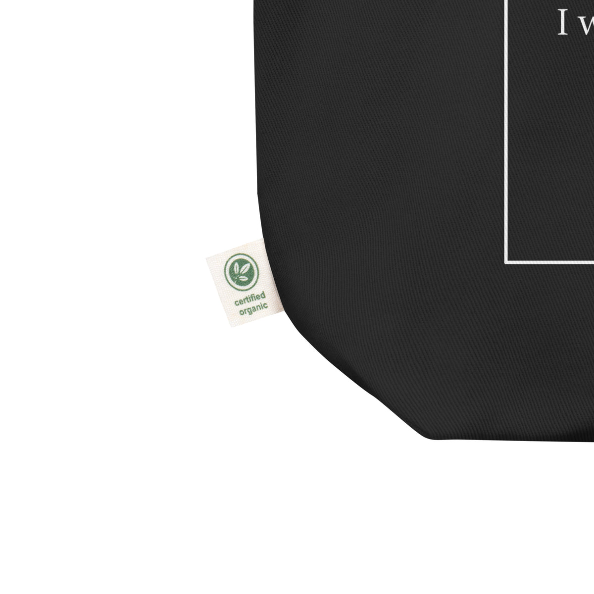Black classic tote bag with a certified organic label on a white background.

