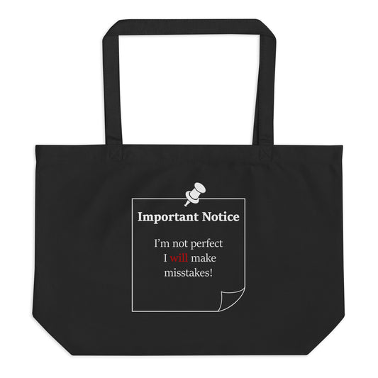 A large organic cotton twill black tote bag featuring a printed white-outlined square note and a white pushpin at the top centre. The note displays the slogan: "Important notice: I’m not perfect, I will make mistakes" in black, with the word will highlighted in bold red for emphasis.