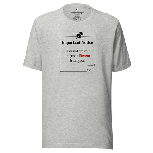 A unisex athletic-heather grey classic cotton t-shirt featuring a printed black outlined square note and a black pushpin at the top centre. The note displays the slogan: "Important notice: I’m not weird i'm just different from you in black, with the word different highlighted in bold red for emphasis.